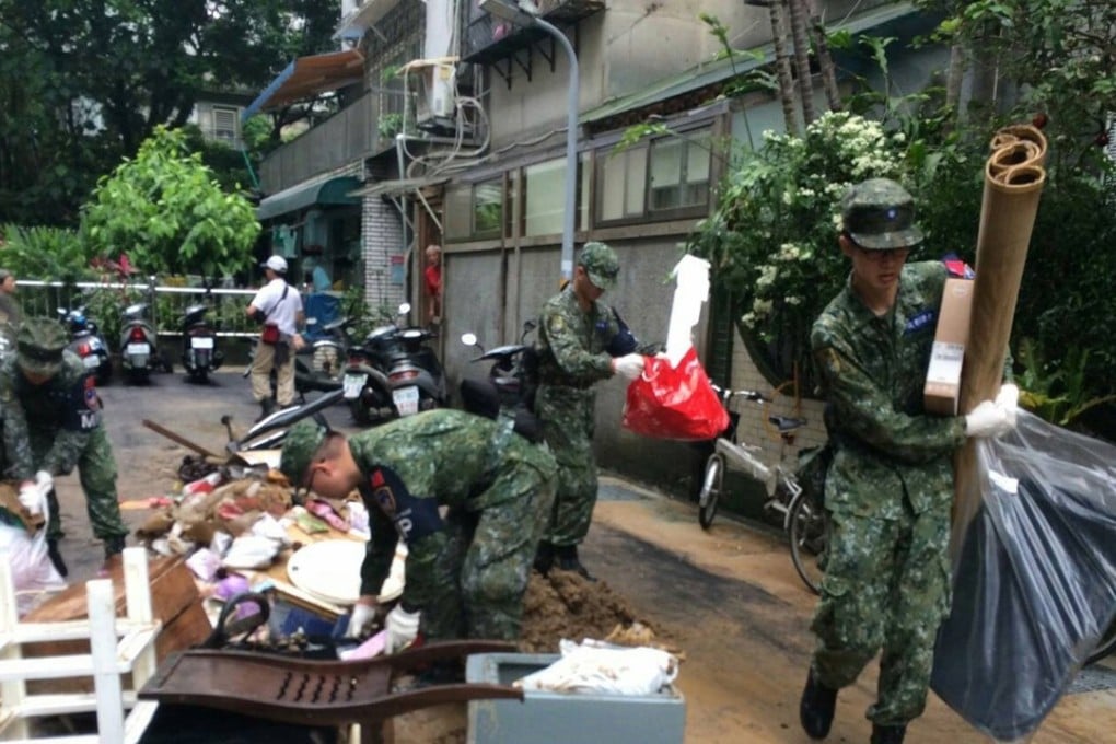 Soldiers help clean up a neighbourhood after flooding in Keelung, northern Taiwan, on Saturday. Photo: EPA