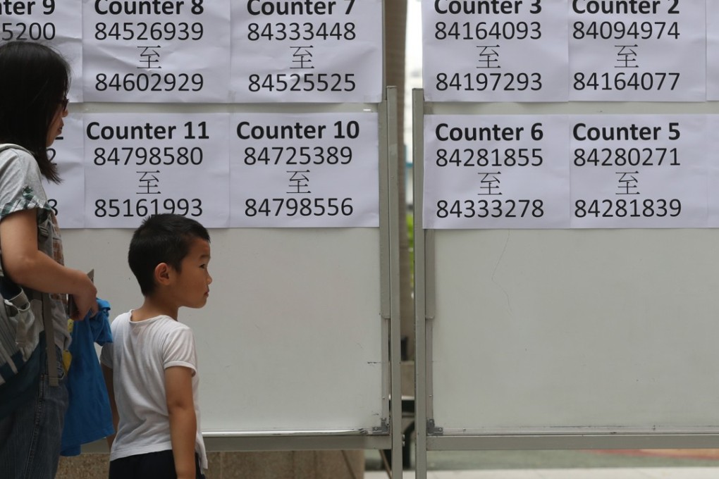 A mother and child look at allocation results at Yaumati Catholic Primary School. Photo: Edward Wong