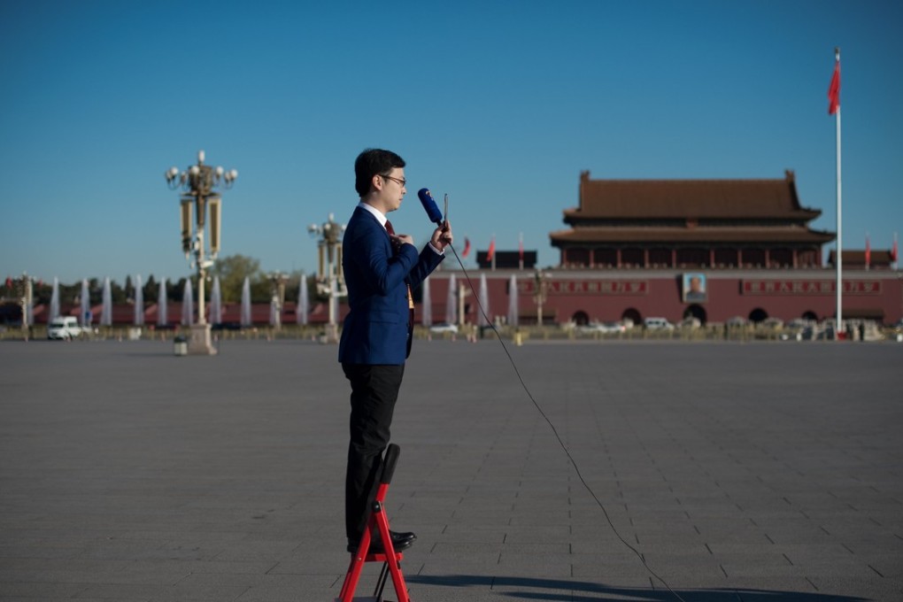 A television journalist stands on a ladder as he reports ahead of the closing ceremony for China’s political advisory body in Beijing in March. Photo: AFP