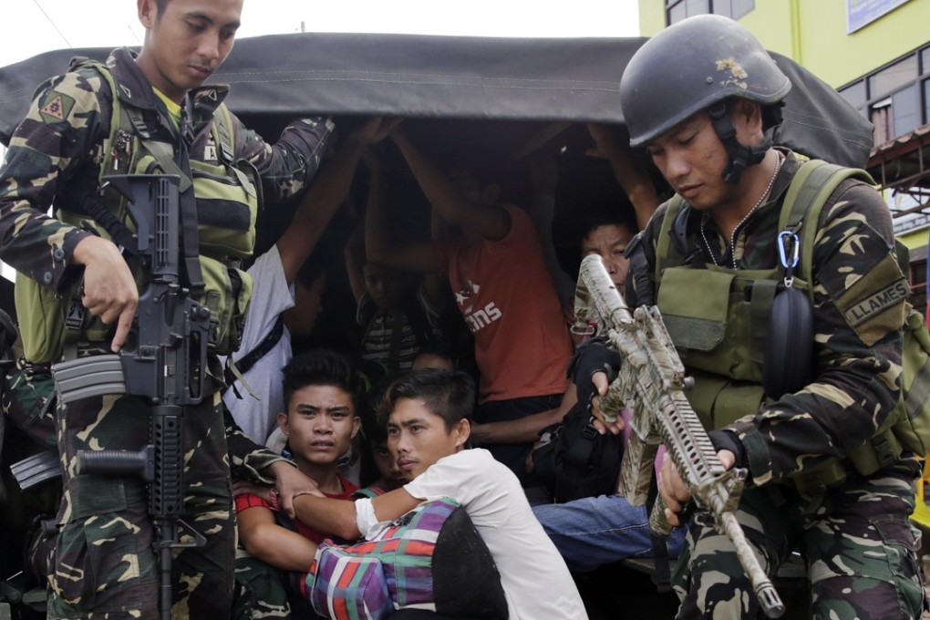 Philippine villagers are escorted by soldiers following their successful escape from Marawi City. Photo: EPA