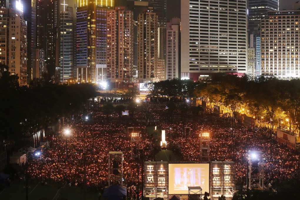 People hold their candle up during the June 4th Candle Light Vigil scene in Victoria Park. 04JUN17 SCMP / Edward Wong