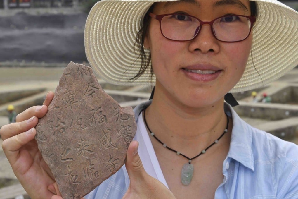 Archaeologist Zhang Xufen shows a fragment of the hundreds of unearthed tablets inscribed with Buddhist scriptures found among the ruins of the Fugan Temple, which stood from the Eastern Jin Dynasty (317-420) until the Southern Song Dynasty (1127-1279). Photo: Xinhua