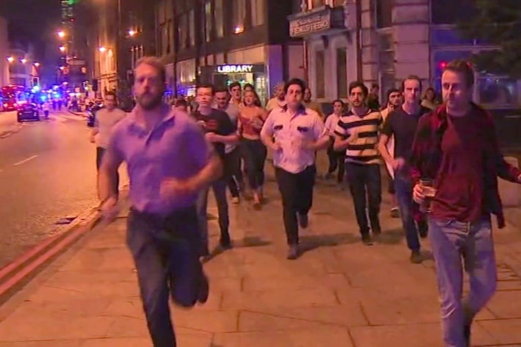 In this image taken from video footage, people exit the scene of the London terror attacks on Sunday, including a man holding a pint of beer (right). Photo: Sky news via AP