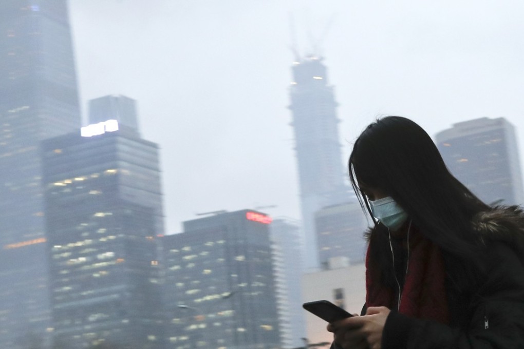 A file picture of a woman checking her phone during heavy smog in Beijing in February this year. Photo: Associated Press