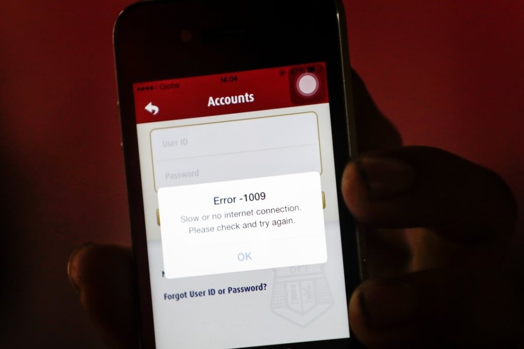 A man shows his mobile phone with a Bank of the Philippine Islands (BPI) application which can not be accessed. Photo: EPA