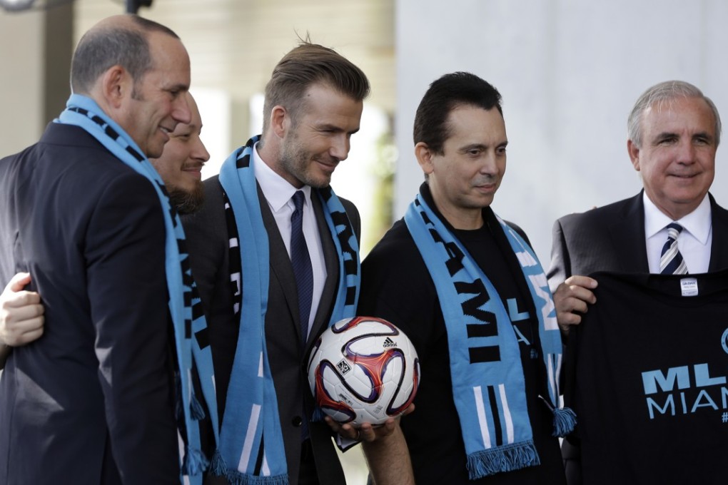 English soccer star David Beckham poses with MLS Commissioner Don Garber (left), Miami-Dade county mayor Carlos Gimenez (right) and soccer fans with the Southern Legion at a news conference where he announced he will exercise his option to purchase a Major League Soccer expansion team in Miami. Photo: AP