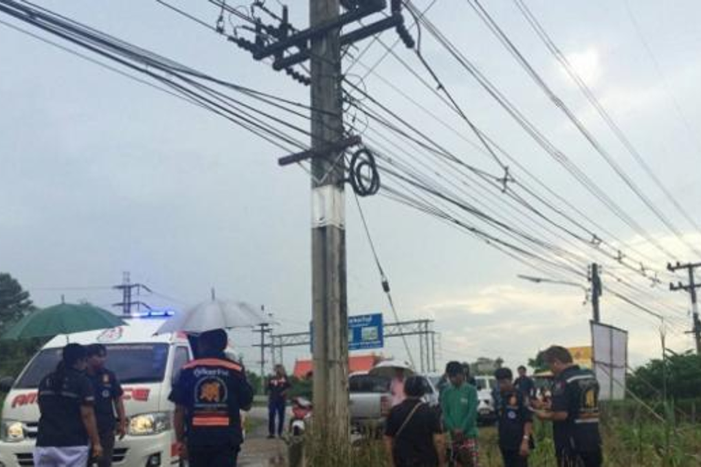 Rescue workers tried unsuccessfully to revive Ratthawut Phanompha after he was electrocuted and fell to the ground. He had been trying to recover a bag of cash attached to a balloon snagged on a high-voltage power pole in Kabin Buri district of Prachin Buri province. Photo: Bangkok Post