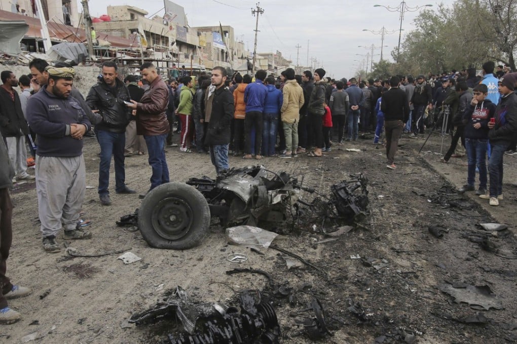 Citizens inspect the scene after a car bomb explosion at a crowded outdoor market in Sadr City, Iraq, on Jan 2. A suicide bomber blew up his explosives-laden vehicle, killing at least a dozen people, amid a fierce regional fight against the Islamic State group. Photo: AP