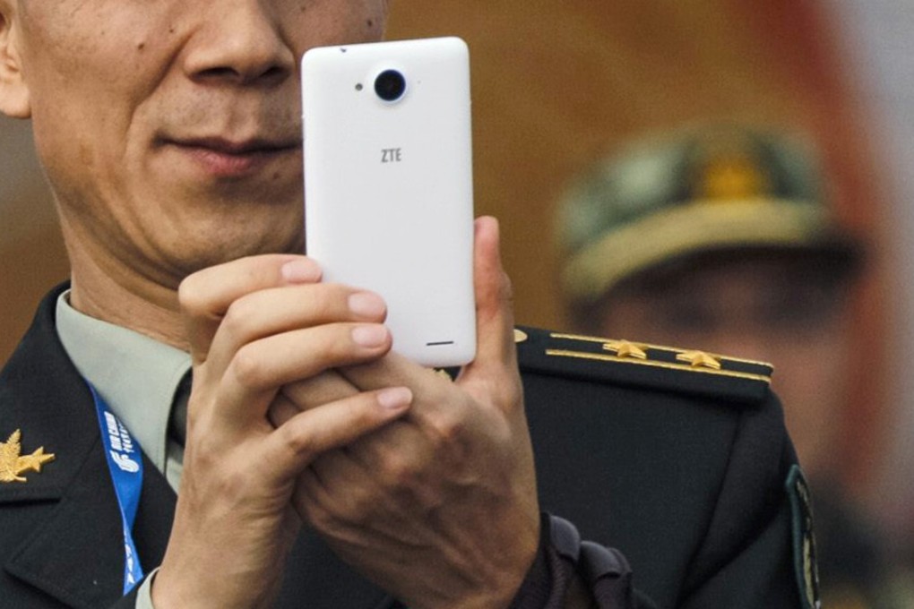 A file picture of a PLA officer using his mobile phone during an air show in Zhuhai. Phone: Reuters