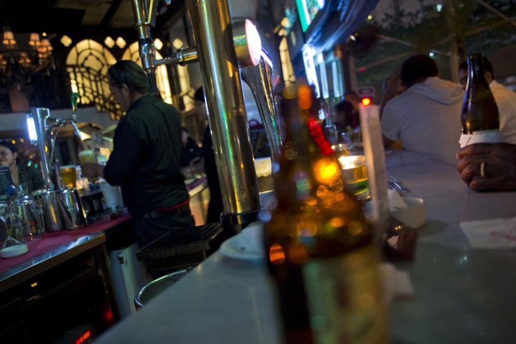A bartender pours beer at a bar in Jakarta. Photo: AFP