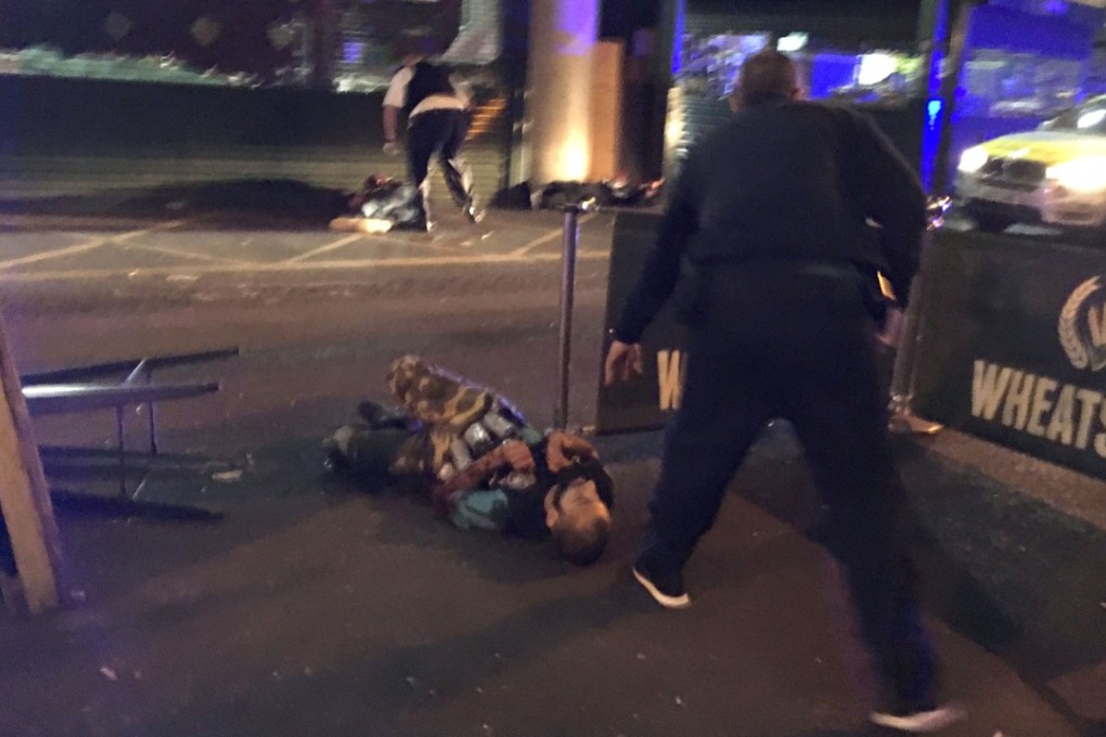 Armed police stand over one of three terrorists shot after an incident at London Bridge and Borough Market last weekend. Photo: AFP
