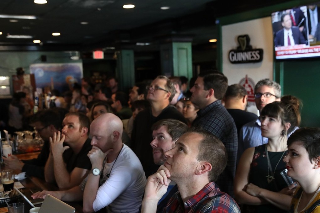 Patrons at Duffy's Irish Restaurant and Bar watch former FBI Director James Comey testify before the Senate Intelligence Committee June 8, 2017 in Washington, DC. Several Washington DC bars and restaurants opened early today for customers to gather to watch the hearing, which some patrons said was similar to the Superbowl. Photo: AFP
