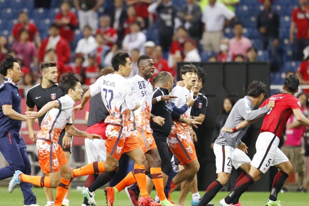Players of South Korea’s Jeju United go after Tomoaki Makino (right), defender of Japan’s Urawa Reds. Photo: Kyodo