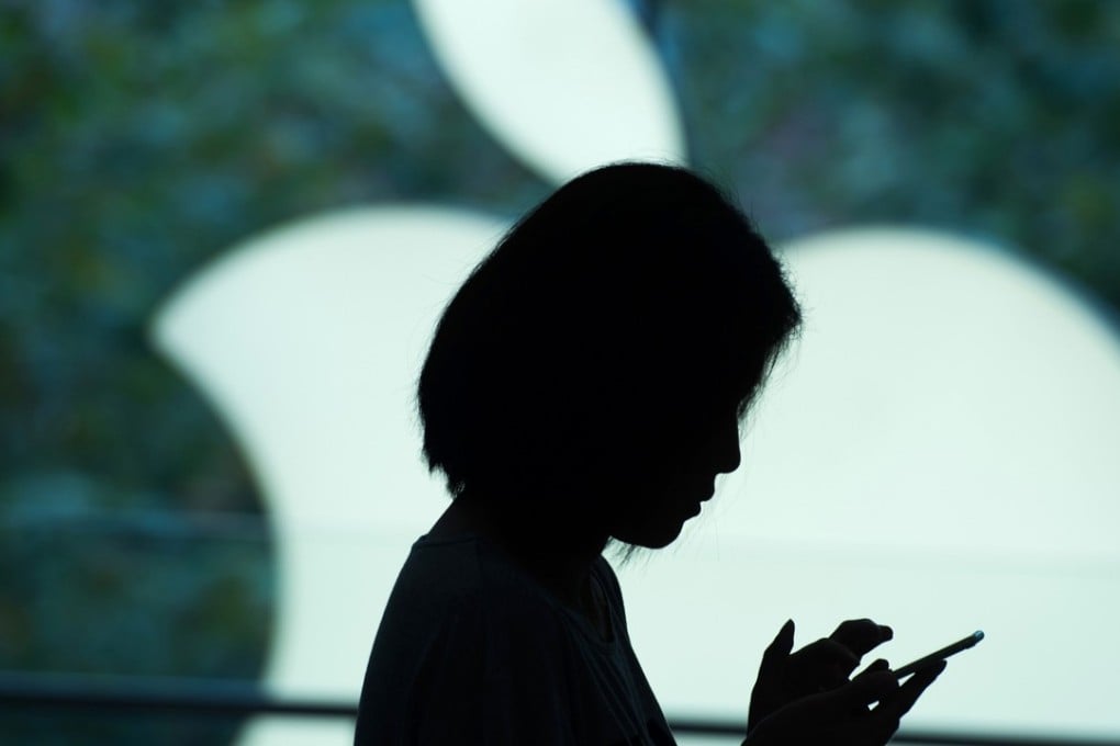 A customer tries a smartphone at an Apple store in Shanghai. Photo: AFP
