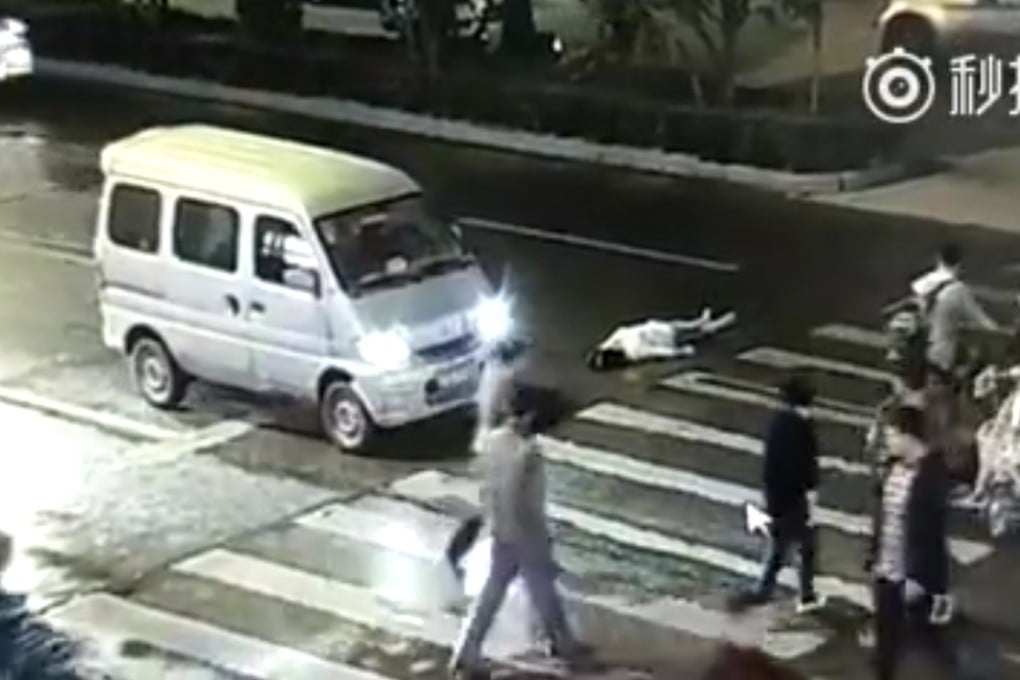 Pedestrians and a motorist ignore the woman as she lies injured in the ground. Photo: Handout