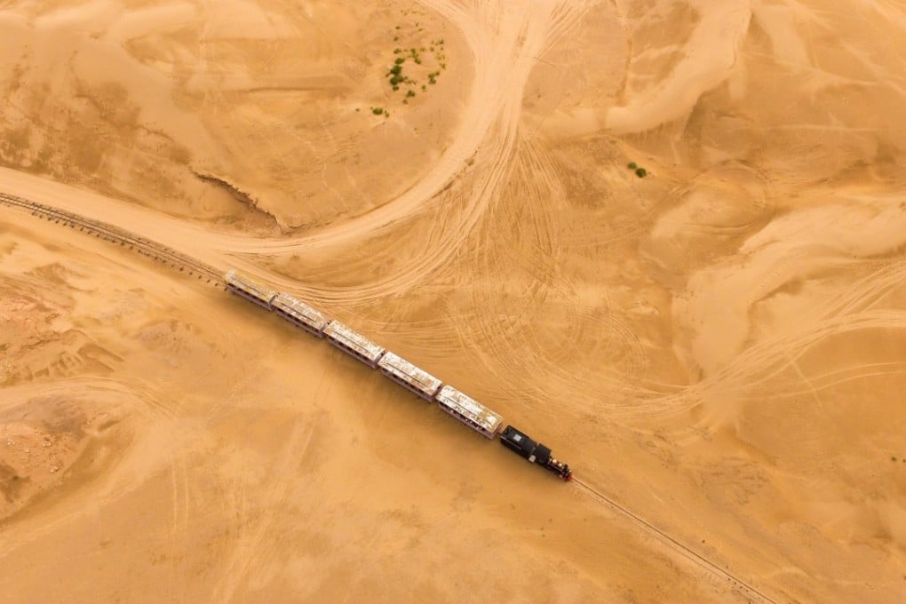 A train runs through the Whistling Dune Bay in Dalad Qi in Ordos, in northern China's Inner Mongolia Autonomous Region. Located to the east of Kubuqi Desert, the Whistling Dune Bay was developed as a tourist destination since 1984. After years of improvement, it became a landmark for tourism industry of the Inner Mongolia Autonomous Region. Photo: Xinhua