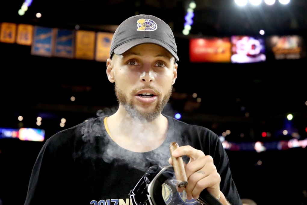 Stephen Curry smokes a cigar after the Golden State Warriors beat the Cleveland Cavaliers 129-120 in game five to win the 2017 NBA Finals at ORACLE Arena. Photo: AFP
