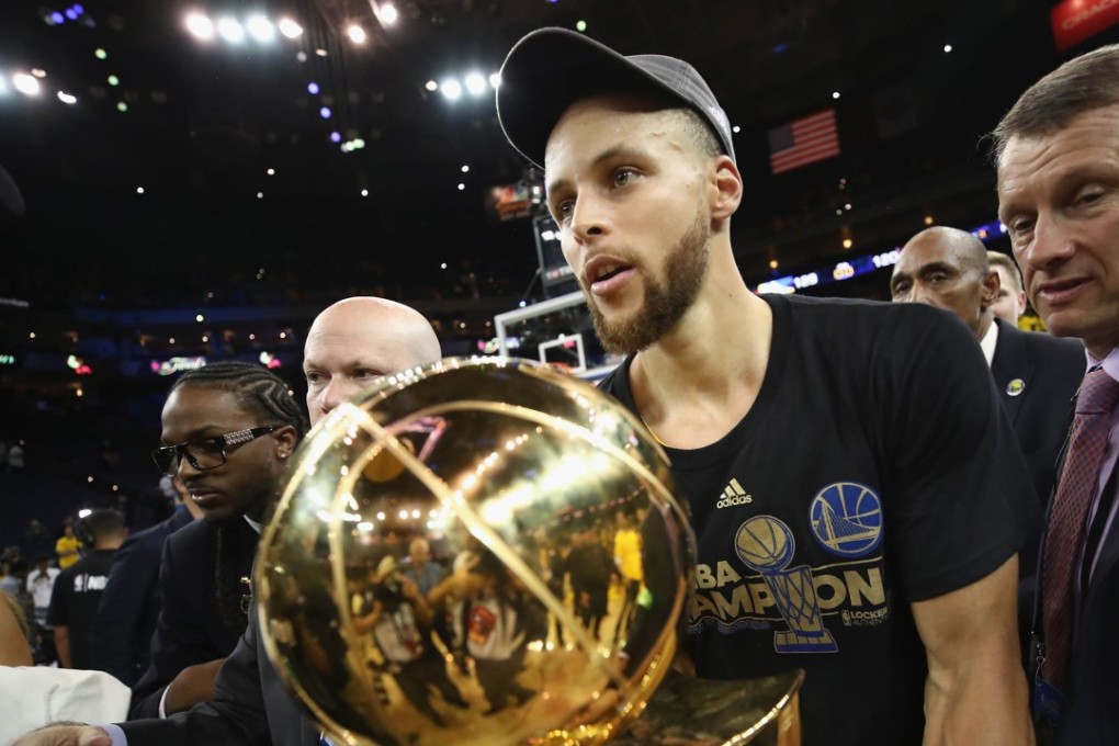 Stephen Curry carries off the Larry O'Brien trophy. Photo: AFP