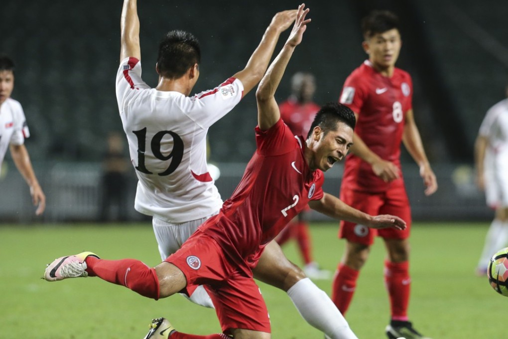 Hong Kong’s Lee Chi -ho (right) is about to hit the ground after clashing with North Korea’s Pak Kwang-ryong during Tuesday night’s AFC Asian Cup qualifier at Hong Kong Stadium. Photos: Felix Wong