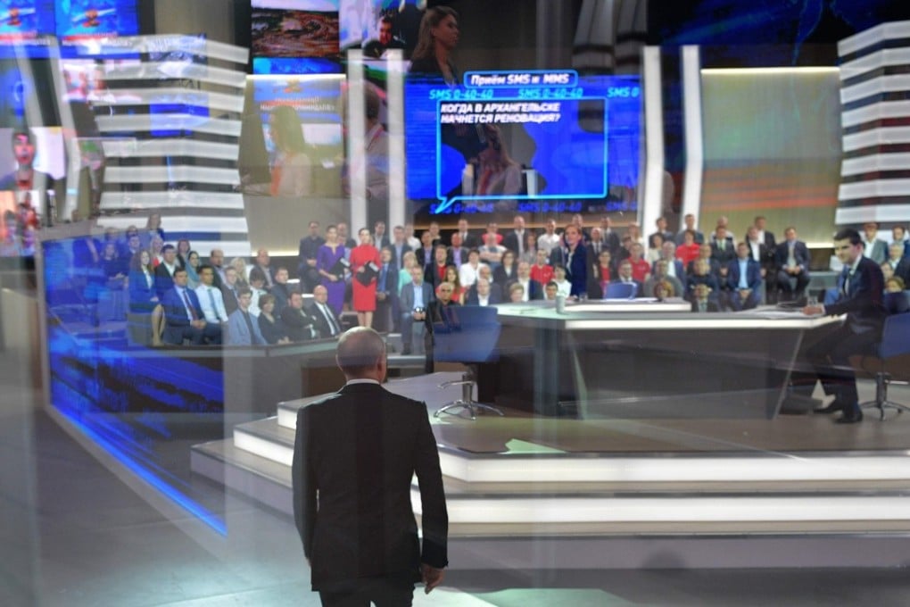 Russian President Vladimir Putin (C) arrives at the Gostiny Dvor studio for the annual ‘Direct Line with Vladimir Putin broadcast live’. Photo: AFP