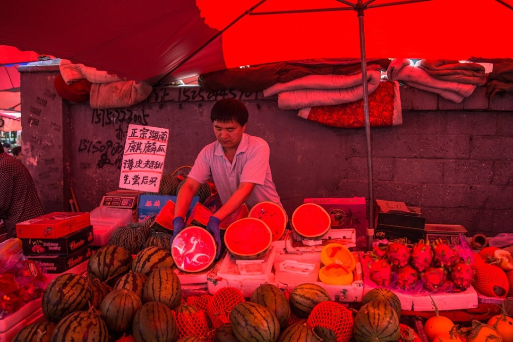 A Chinese vendor waits for buyers at his fruit stall in a market in Beijing. For China, the Fed’s reduction in its balance sheet will put the People’s Bank of China in a difficult position, say analysts, with many financial institutions already facing tighter liquidity due to the ongoing regulatory crackdown. Photo: EPA