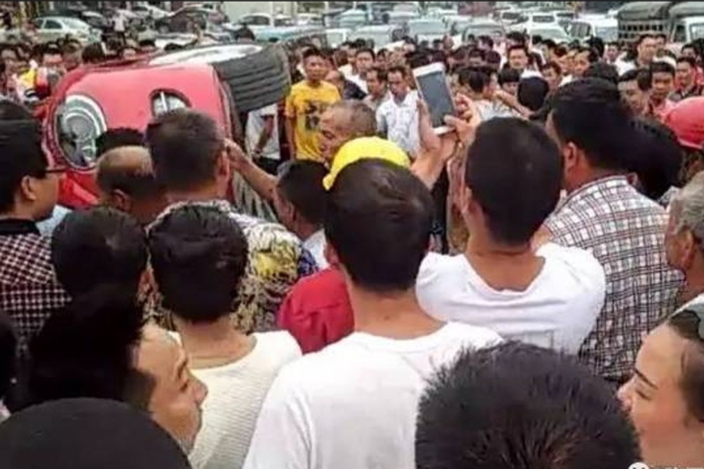 The angry crowd tip the car over. Photo: Sina.com.cn