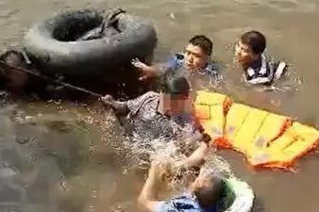 Police and two passers-by, who also jumped into the water, pictured finally getting the man to safety. Photo: Sina.com.cn