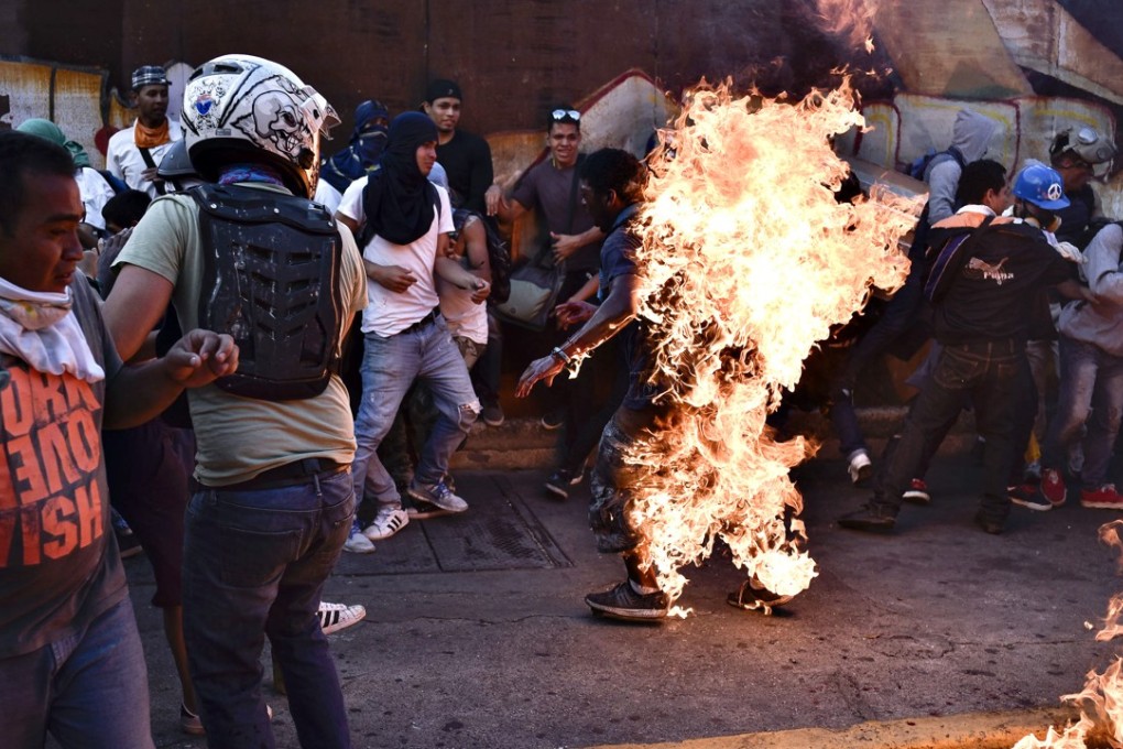 Opposition demonstrators set an alleged thief on fire during a protest against the government. Photo: AFP