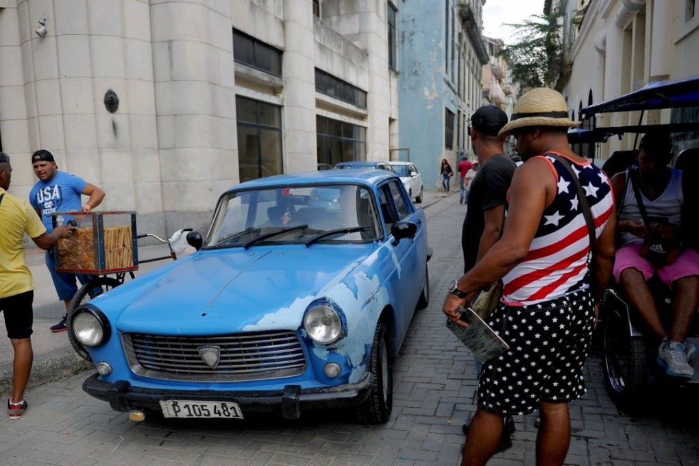 A Cuban wearing a T-shirt with the US flag stands in a street in Havana, on June 15, 2017. / AFP PHOTO / YAMIL LAGE