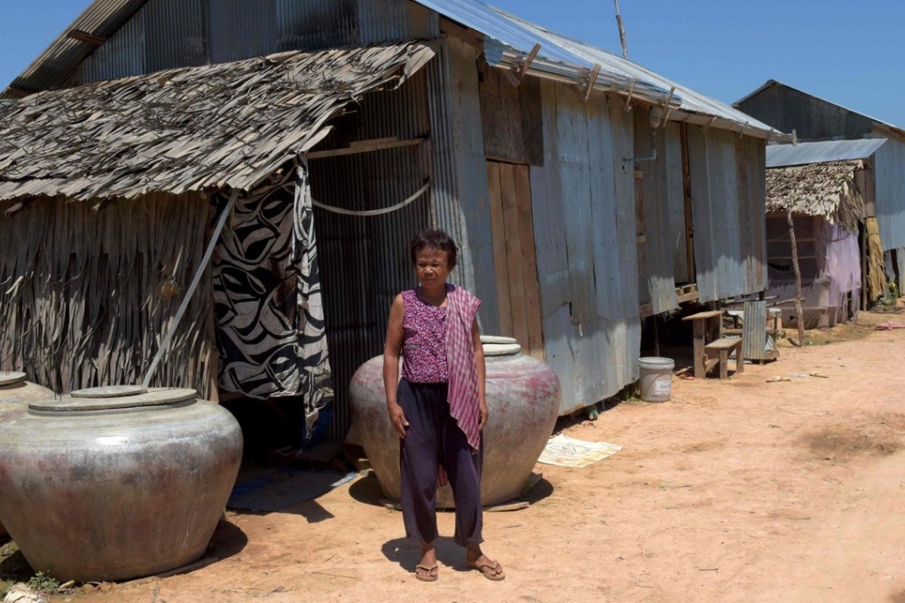 Chhum Long, whose daughter was a surrogate mother, standing in front of her house in the village of Puth Sar. Photo: AFP