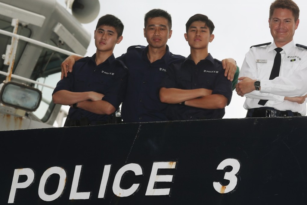 Marine police officers Lam Ho-long (left), father Lan Cheuk-lun, Lam Ho-chun and Tim Worrall (right) on a boat at headquarters in Sai Wan Ho. Photo: K. Y. Cheng