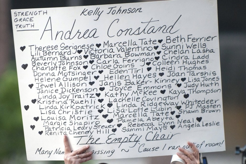 A woman holds a sign with the names of the women who have accused US entertainer Bill Cosby of sexual abuse. Photo: EPA