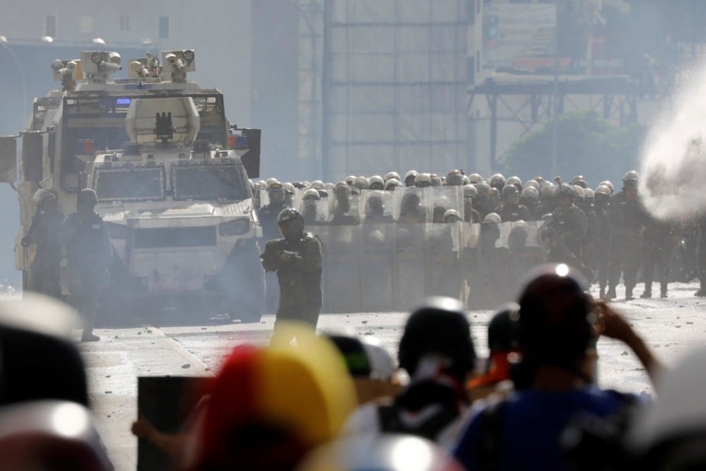 Demonstrators clash with riot security forces in Caracas. A VN-4 armoured personnel carrier, made by China’s defence conglomerate China North Industries Group Corp, or Norinco is in the foreground. Photo: Reuters