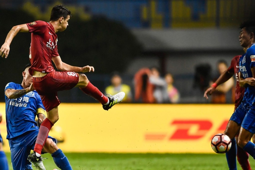 Shanghai SIPG’s Oscar (left) launches the ball at a Guangzhou R&F player. Photos: AFP