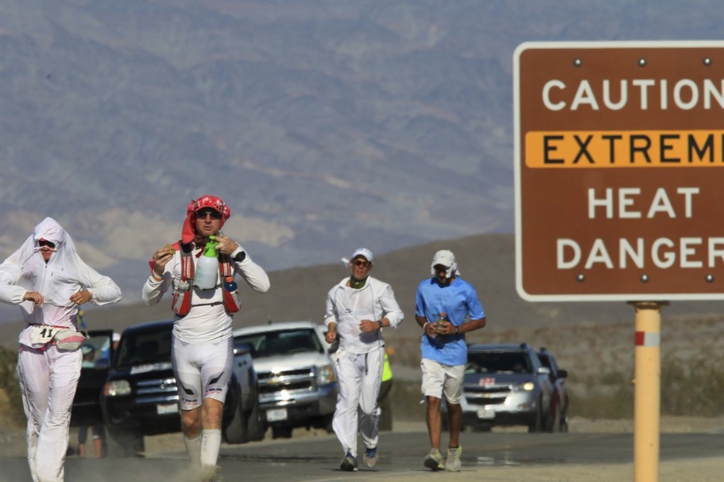 Runners pass a heat danger warning sign during the AdventurCORPS Badwater 135 ultra-marathon race on July 15, 2013 in Death Valley National Park, California. Temperatures in the hottest place in the US are expected to hit a scorching 53 Celsius this week. Photo: AFP