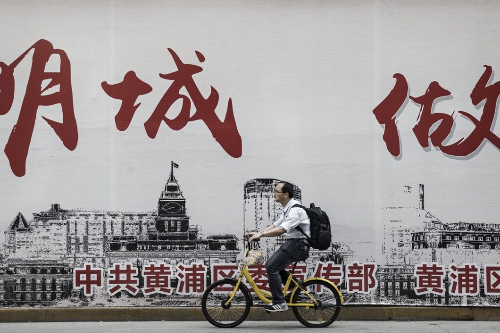 A commuter rides an Ofo bicycle along a sidewalk in Shanghai. In China, a bicycle-sharing phenomenon is changing the way urban dwellers get around, and forcing listed manufacturers to scramble to get a slice of the profits. Photo: Bloomberg