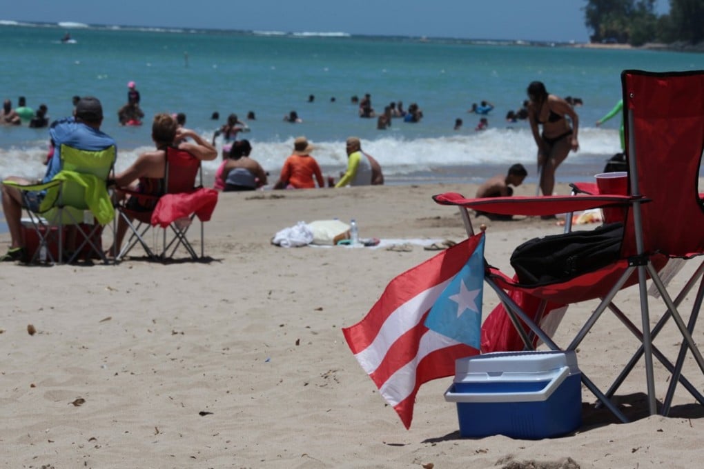 People spend time at the beach on June 11 as Puerto Ricans headed to the polls to vote in a referendum on the future of the US territory. Photo: Reuters