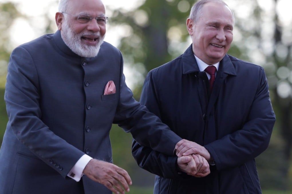 Russian President Vladimir Putin and Indian Prime Minister Narendra Modi hold hands during a walk this month in a park in St Petersburg. Photo: EPA / TASS Host Photo Agency