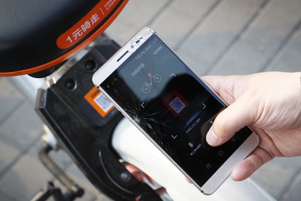 A commuter in Beijing uses an app to unlock a Mobike bicycle. The bike-sharing company has announced plans to expand to Japan. Photo: AP