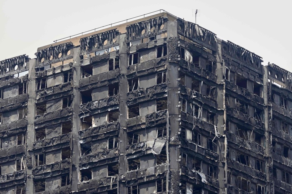 The charred remains of clading are pictured on the outer walls of the burnt out shell of the Grenfell Tower block. Photo: AFP