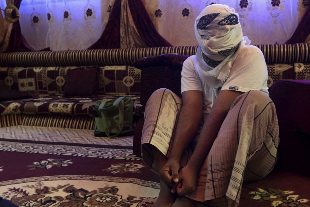 A former detainee shows how he was kept in handcuffs and leg shackles while held in a secret prison at Riyan airport in the Yemeni city of Mukalla. He covered his face for fear of being identified and detained again. Photo: AP