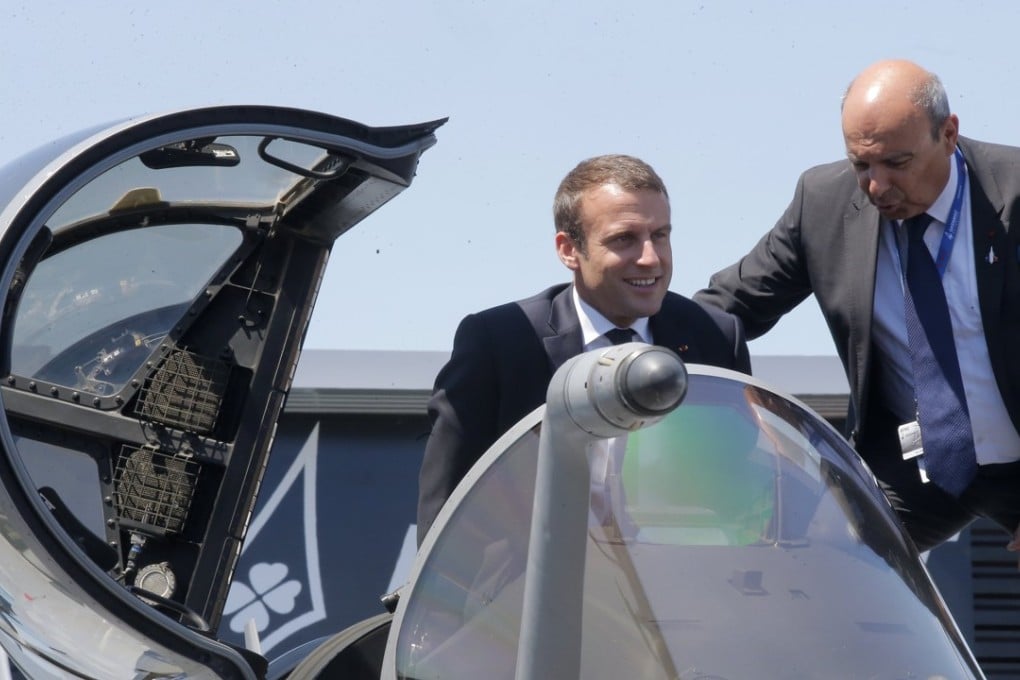 French President Emmanuel Macron exits the cockpit of a Rafale jet fighter helped by Dassault Aviation CEO Eric Trappier while visiting the Paris Air Show in Le Bourget, north of Paris, on June 19. Photo: EPA