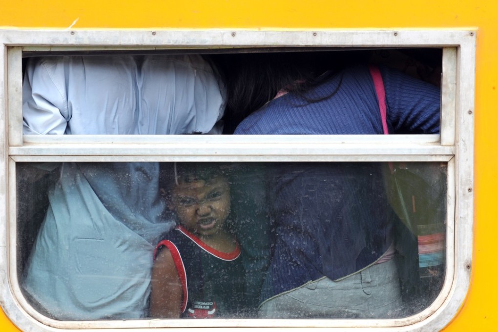 A young passenger is squeezed into an economy carriage at the Jakarta train station as her family returns to their home provinces to celebrate Eid al-Fitr, marking the end of Ramadan. Photo: AFP