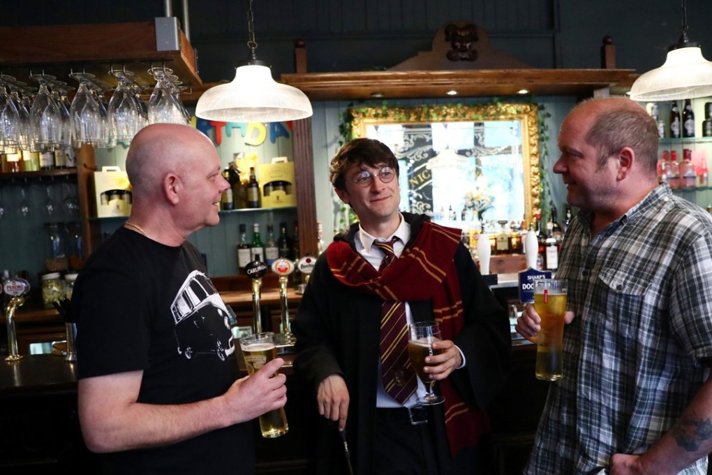 Professional Harry Potter impersonator Luke Williams (C) enjoys a drink at a pub in London, Britain. Hundreds of Harry Potters celebrated the 20th anniversary of the first publication of the series. Photo: Reuters