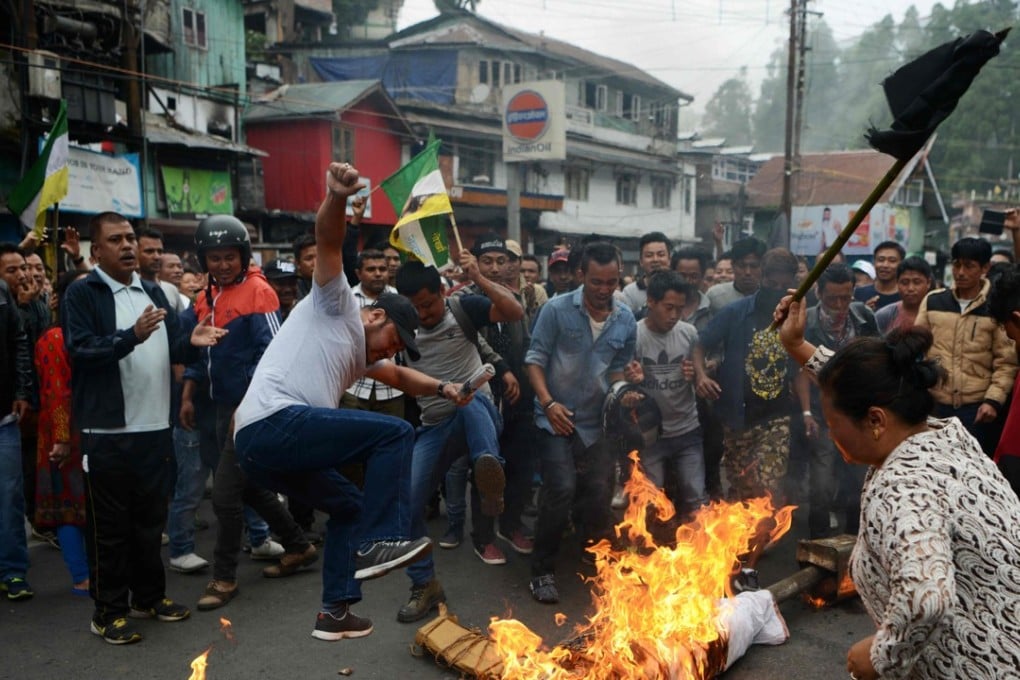 Supporters of the Gorkha Janmukti Morcha group burn an effigy of West Bengal Chief Minister Mamata Banerjee. Photo: AFP