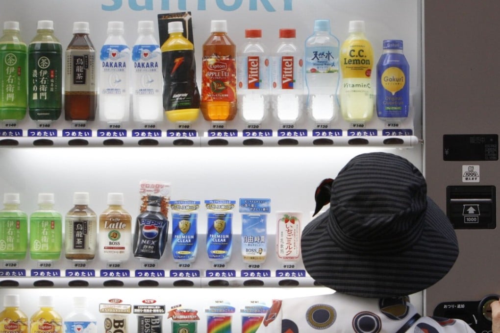 A woman purchases a Suntory beverage from a vending machine in Tokyo. File photo: Reuters