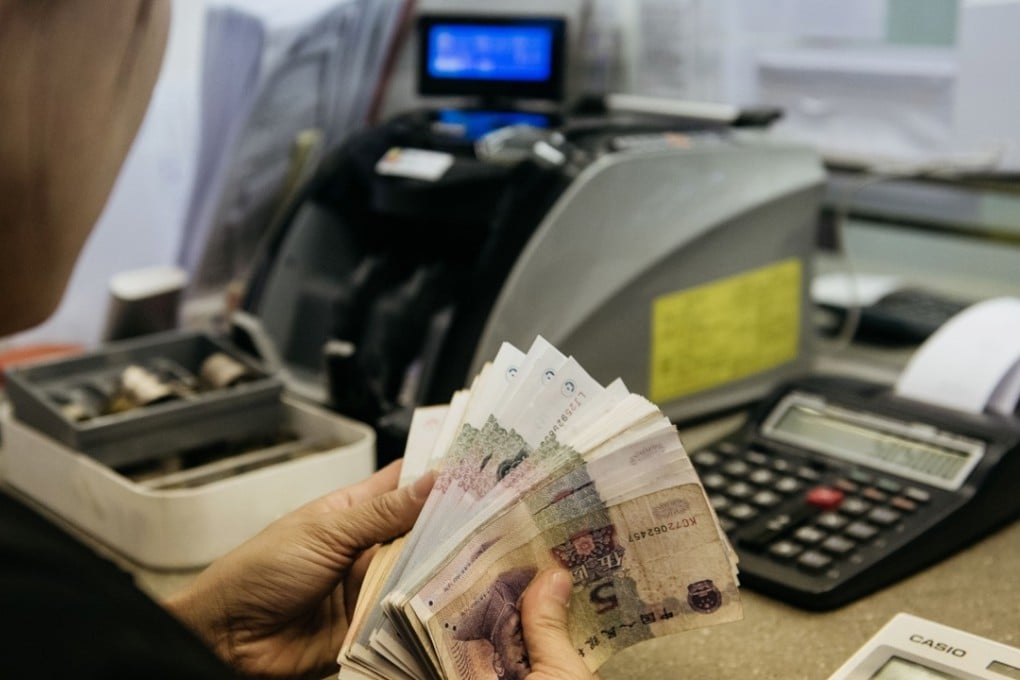 An employee counts Chinese five yuan banknotes at the Professional Foreign Currency Exchange Ltd. (PFCE) store in Hong Kong. Photo: Bloomberg