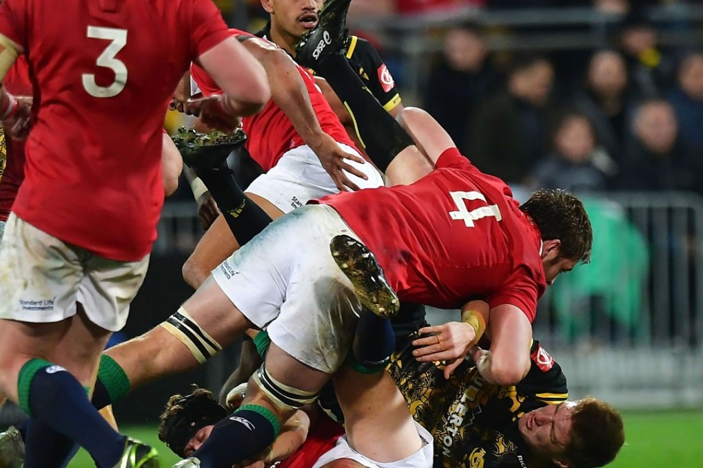 Wellington Hurricanes’ Jordie Barrett (bottom right) is tackled by British & Irish Lions player Iain Henderson. Photo: AFP