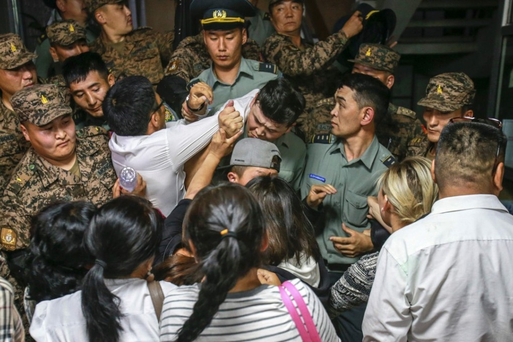 Activists from the Mongolian People's Revolutionary Party scuffle with security personnel at the press centre in Ulan Bator. Photo: AFP