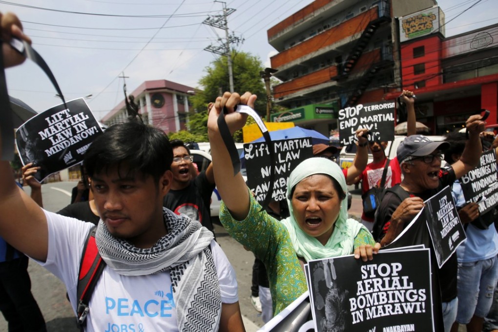 Protesters stage a demonstration dubbed “Black Friday” to mark the first month of the declaration of martial law in Mindanao, near the presidential palace in Manila on June 23. Photo: EPA